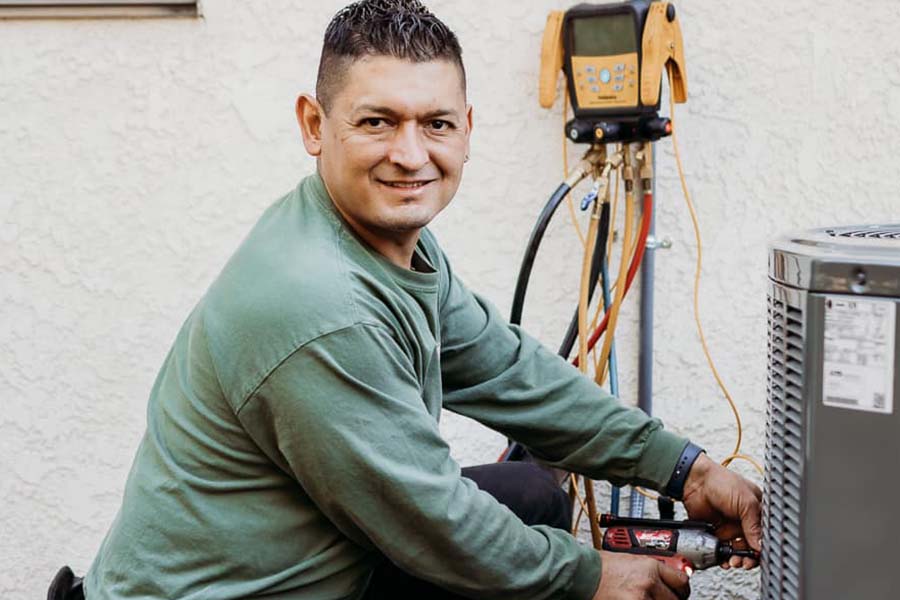 Technician repairing an outdoor air conditioning unit